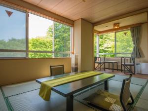 a room with a table and chairs and windows at Hotel Oakhill in Zaō Onsen