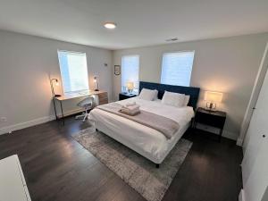 a bedroom with a bed and a desk and two windows at Modern House with Terrace Near Forest Park in Saint Louis