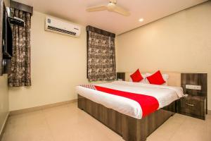 a bedroom with a bed with red pillows at OYO Flagship Hotel Galaxy Palace in Ajmer