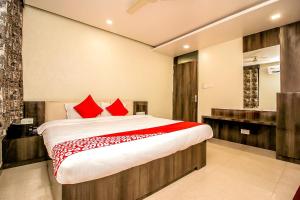 a bedroom with a large bed with red pillows at OYO Flagship Hotel Galaxy Palace in Ajmer
