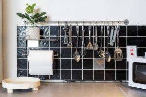 una cocina con una pared de azulejos negros con utensilios. en Broadgate Penthouse Apartment, en Bradford