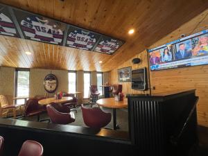 a restaurant with tables and chairs and a tv on the wall at The Patch Lodge in Warroad