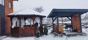 un cenador con nieve encima en Casa Transylvania en Lupşa