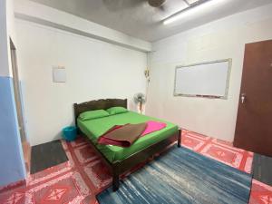 ein Schlafzimmer mit einem grünen Bett in einem Zimmer in der Unterkunft MY GUNUNG HOTEL BUDGET 