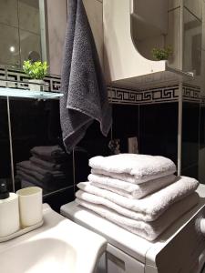 einen Stapel Handtücher auf einer Theke im Bad in der Unterkunft Max in Fontana