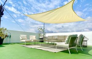 d'une terrasse avec des chaises et une table à baldaquin. dans l'établissement Habitación en Playa Malvarrosa con baño privado -No AC-, à Valence