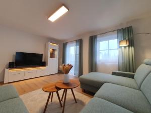 uma sala de estar com um sofá e uma televisão em Ferienwohnungen Winkler em Bischofswiesen