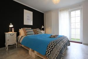 una camera da letto con un grande letto e un piumone blu di Norsk Skogkatt Galati - Big Tv DISNEYplus TV, disscount on Google! a Galaţi