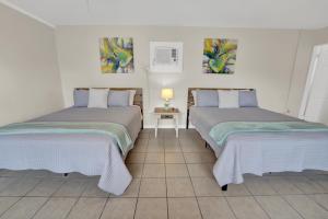 two beds sitting next to each other in a room at Sea Foam Suites in Panama City Beach