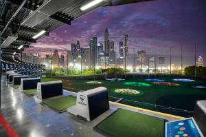 a golf course with a city skyline in the background at 1 bedroom Apartment with Dubai Marina & Seaview in Dubai