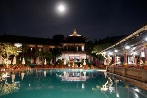 a pool in front of a building at night at Galayanee’s Resort Apartment in Seminyak