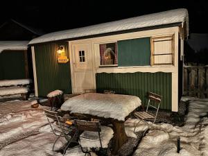 una casa con mesa y sillas en la nieve en an der GEIERWAND, en Haiming