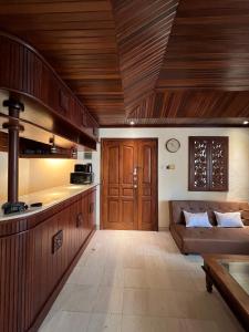 uma sala de estar com um sofá e um tecto de madeira em Galayanee’s Resort Apartment em Seminyak