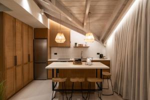 a kitchen with a table and stools in a room at YOLO Resort - Loft in Alykes +21 photos