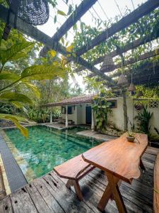 a patio with a wooden table and a swimming pool at Medusa Bungalow - Galle in Galle