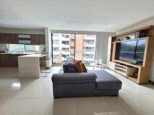 - un salon avec un canapé et une télévision dans l'établissement New Luxury 3 Bedroom Apartment in Great Area., à Medellín