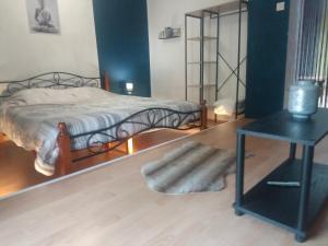 1 dormitorio con 1 cama y 1 mesa con sidra de mesa en Le Petit Veternat en Ventron