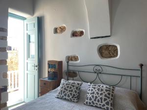 ein Schlafzimmer mit einem Bett und einige Steine an der Wand in der Unterkunft Folegandros-Cliffhouse in Folegandros Chora