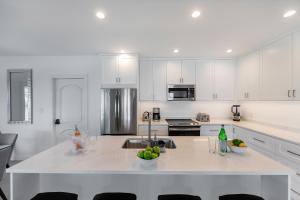 a kitchen with white cabinets and a white counter top at Carpe Diem 3 BR Condo in The Bight Settlements