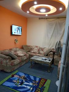 sala de estar con 2 sofás y TV en شقه بجوار البحر الهدوء والأمان شاطئ اكسجين, en Alejandría