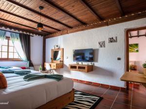 a bedroom with a large bed and a tv at Room in Bungalow - Triple Bungalow 6 - El Cortijo Chefchaeun Hotel Spa in Chefchaouen