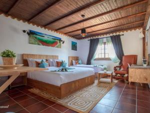 シェフシャウエンにあるRoom in Bungalow - Triple Bungalow 6 - El Cortijo Chefchaeun Hotel Spaのベッドルーム1室(ベッド2台、テーブル、椅子付) +37枚の写真