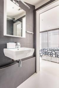 a bathroom with a sink and a bed at Casa Olmi in Shoreditch in London