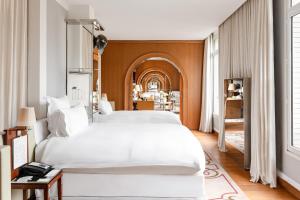 a bedroom with a large white bed in it at H&ocirc;tel Le Royal Monceau Raffles Paris in Paris