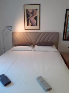 ein großes weißes Bett mit zwei Kissen darauf in der Unterkunft Apartman Mona in Mostar