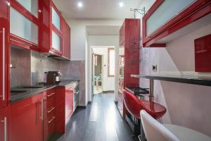 d'une cuisine avec des placards rouges et une chaise rouge. dans l'établissement 2Bedroom Flat@Lisbon town center, à Lisbonne