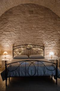 a bedroom with a bed with a stone wall at DOMUS Casa Vacanze in Terlizzi