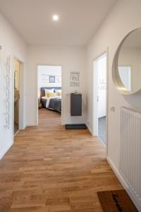 a hallway with a bedroom and a bed and a mirror at Goethe Palais Suite Anna Amalia l 1-8P l Lift l Parkplatz in Aue