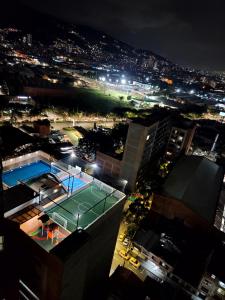 a tennis court on top of a building at night at Modern High-Rise 2/2 Apartment with City View. in Sabaneta