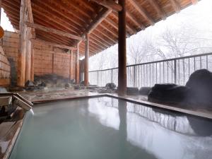 a pool of water in a building with snow at Hotel Oakhill in Zaō Onsen