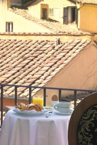 einen Tisch mit einem Teller Essen und Kaffee darauf in der Unterkunft Hotel Teatro Pace in Rom