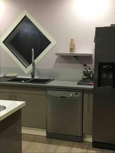 eine Küche mit einem Waschbecken und einem TV auf der Theke in der Unterkunft Villa piscine et jacuzzi in Ychoux