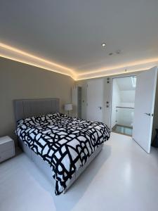 - une chambre avec un lit et une couette noire et blanche dans l'établissement Casa Olmi in Shoreditch, à Londres