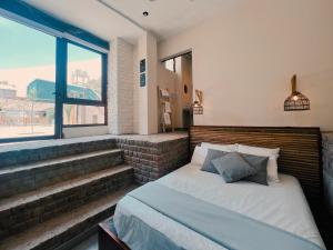 a bedroom with a bed and a large window at Viajero Kokopelli Huacachina Hostel in Ica