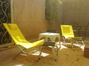 three yellow chairs and a table in a patio at 3 bedrooms villa with private pool and enclosed garden at Marrakech in Marrakesh