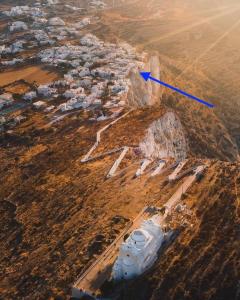 Vue aérienne d'une montagne avec une flèche bleue dans l'établissement Folegandros-Cliffhouse, à Folégandros