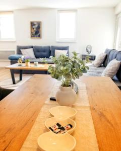 a living room with a wooden table with a vase at Vikendica Jadranka in Kupres