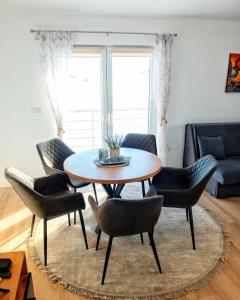 a table and chairs in a living room with a couch at Vikendica Jadranka in Kupres