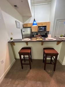 a kitchen with two stools and a counter with a microwave at Charming 2Bd/2bth Retreat in Downtown Richmond in Richmond