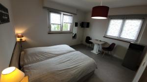 1 Schlafzimmer mit einem Bett, einem Schreibtisch und 2 Fenstern in der Unterkunft Résidence La Clef des Champs in Morsbronn-les-Bains