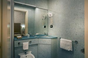 a bathroom with a sink and a toilet and a mirror at Hotel Galimberti in Turin