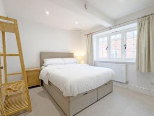a bedroom with a bed and a ladder and a window at The Hive - Pet Friendly House - Emsworth in Emsworth