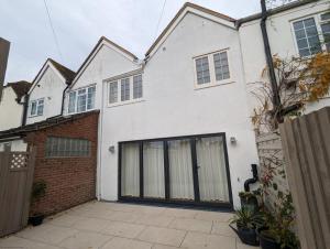 une maison blanche avec un garage dans l'établissement The Hive, à Emsworth