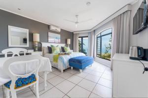 a bedroom with a bed and a desk and a table at Lalaria Ocean Villa Suite 3 in Ballito