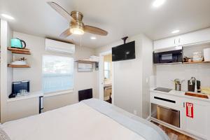 a bedroom with a white bed and a kitchen at Beach 5 Villas #B3 in Fernandina Beach