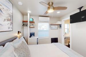 Beach 5 Villas #B3 في فرناندينا بيتش: غرفة نوم بسرير ومروحة سقف